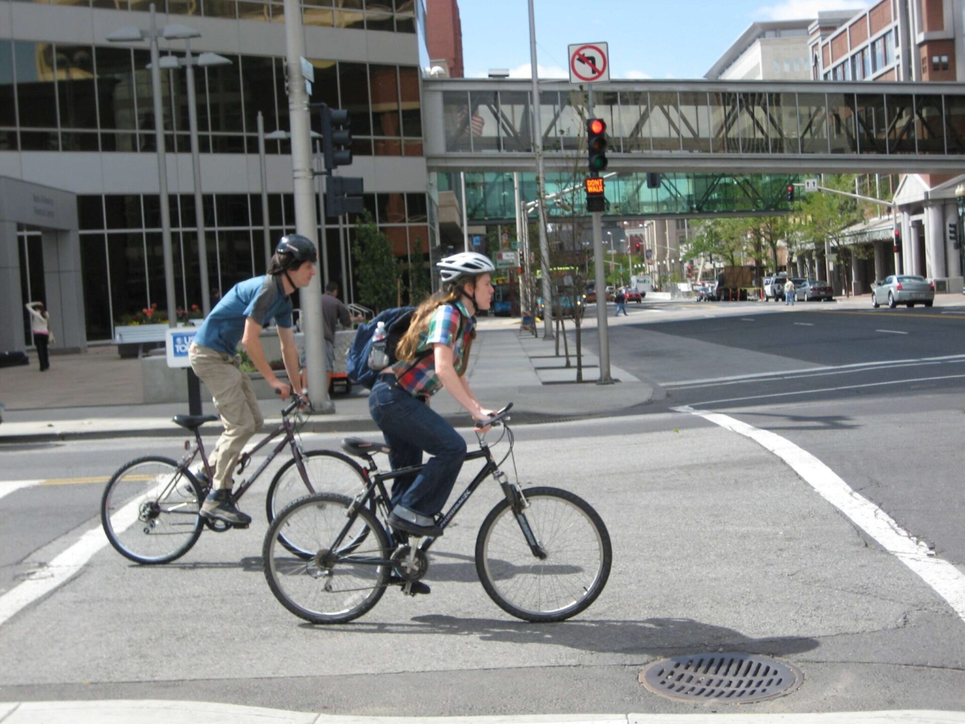 Two people biking downtown.
