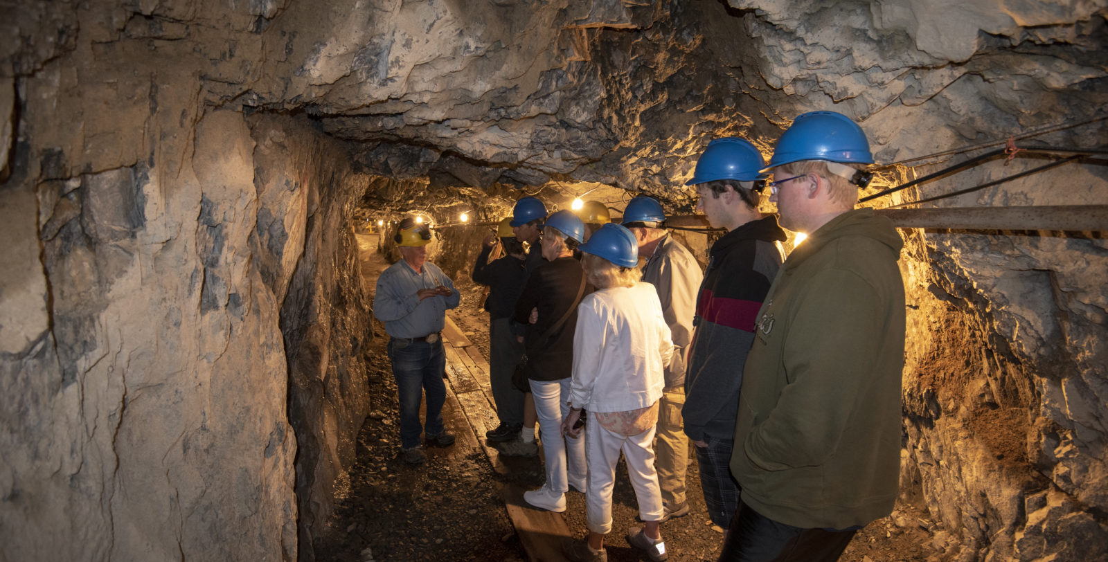 A tour group walking through a mine shaft.