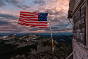 An american flag flying on top of a mountain.