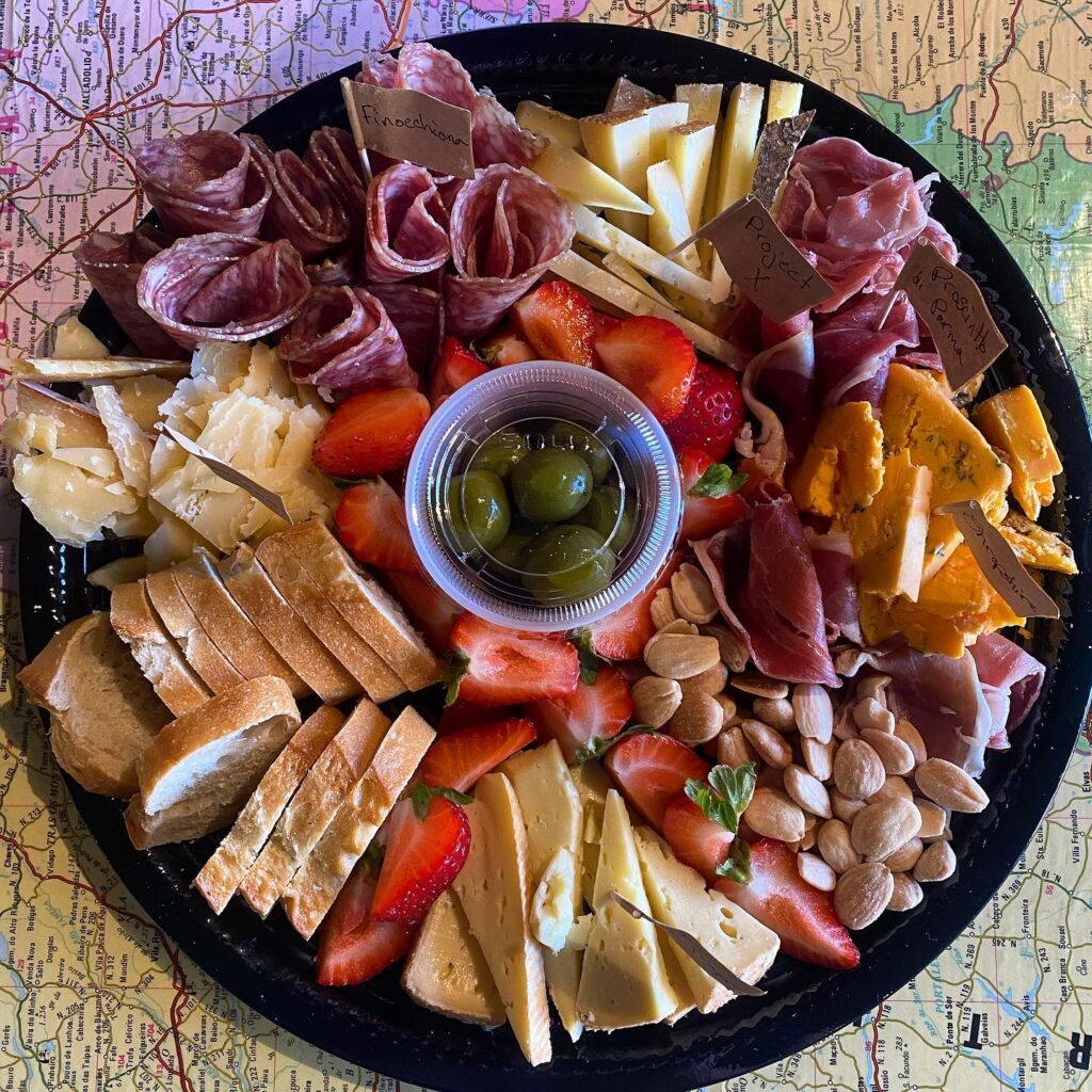 Charcuterie board of assorted cheeses, meats, nuts, berries and breads.