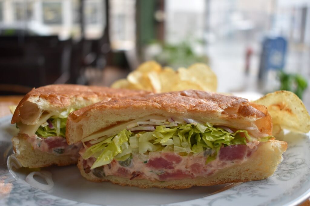 Tuna salad sandwich with lettuce and artisan bread.