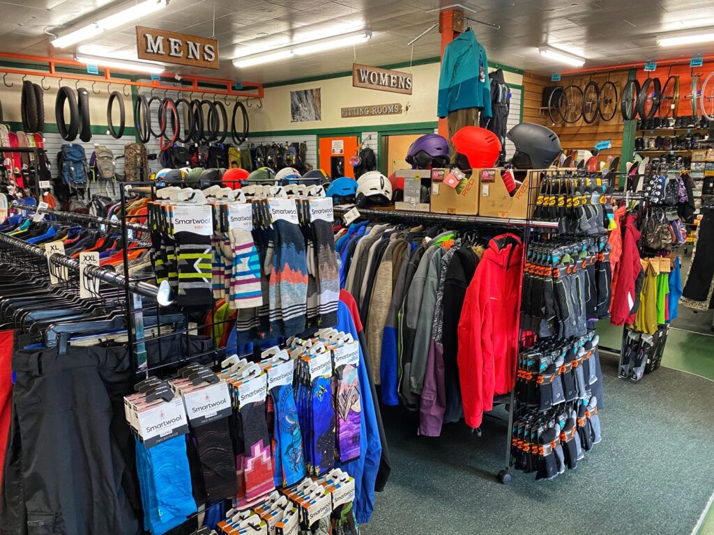 Racks of ski clothing gear inside a retail shop.