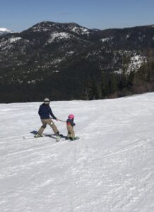 Mother teaching daughter to ski at 49 degrees north.