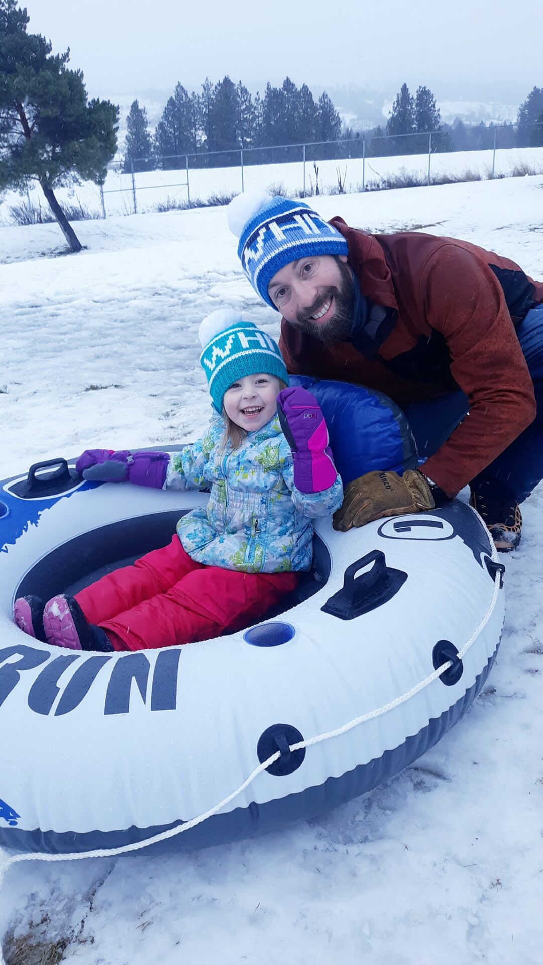 Father and daughter snow tubing.