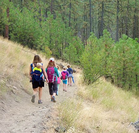 Kids and moms hiking along the trails at High Drive Bluff Park in Spokane.