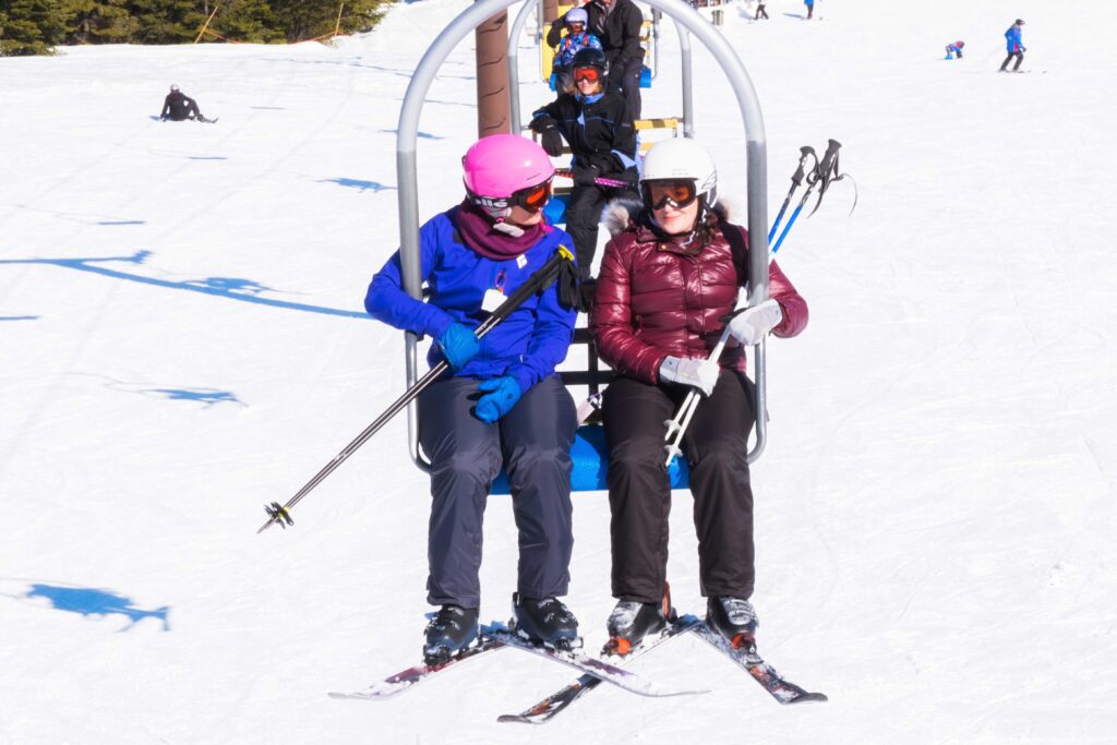 Two skiers riding a double-chairlift.