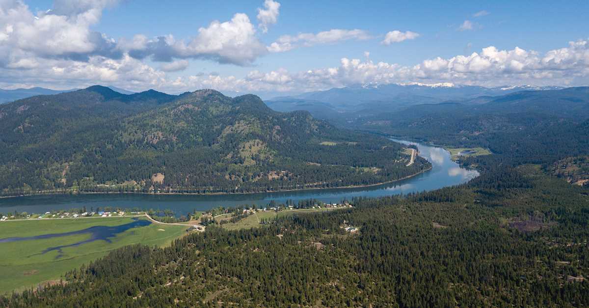Aerial view of the Pend Oreille River valley, with forested hillsides.
