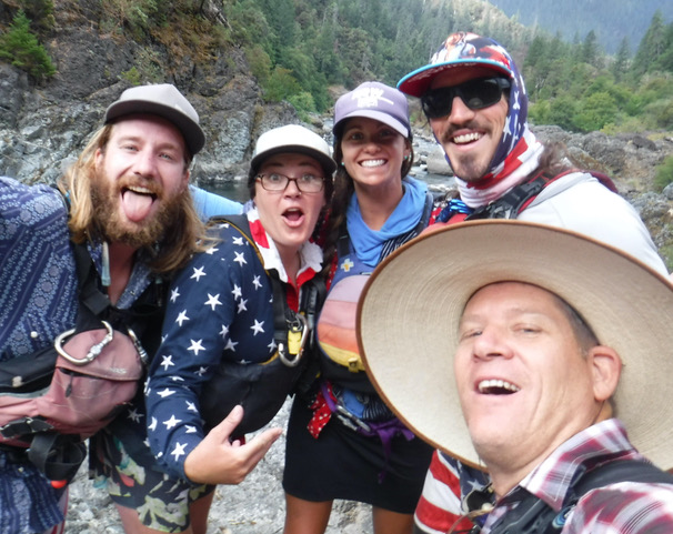 River guides wearing hats, gathered together for a funny group photo -- with wide smiles, mouths open.