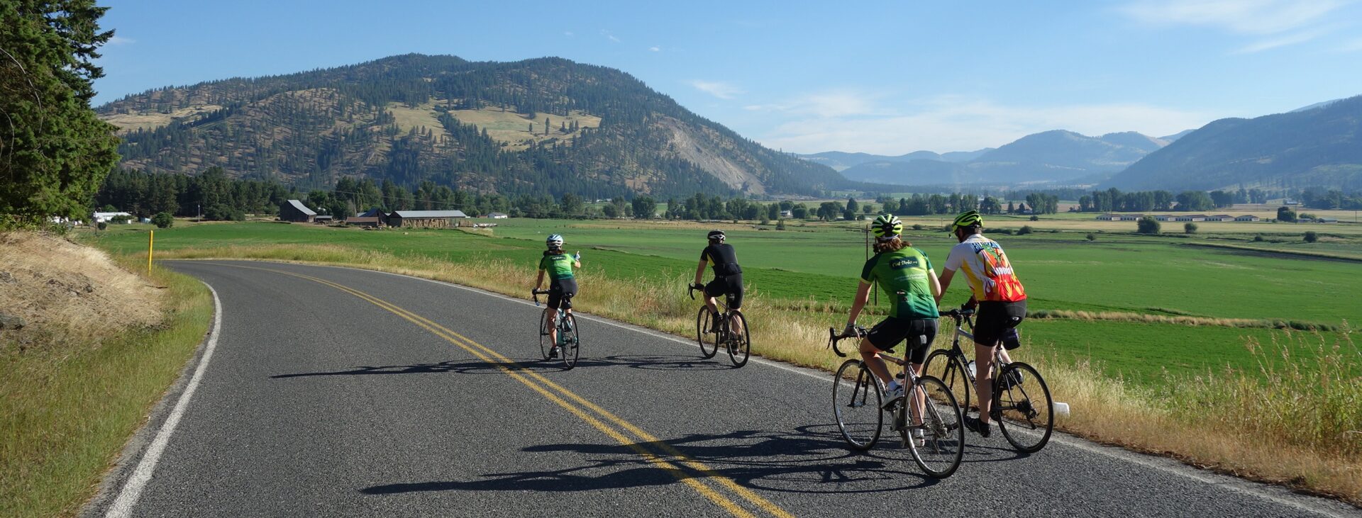 Cyclists riding in Colville, Wash., along a rural road.