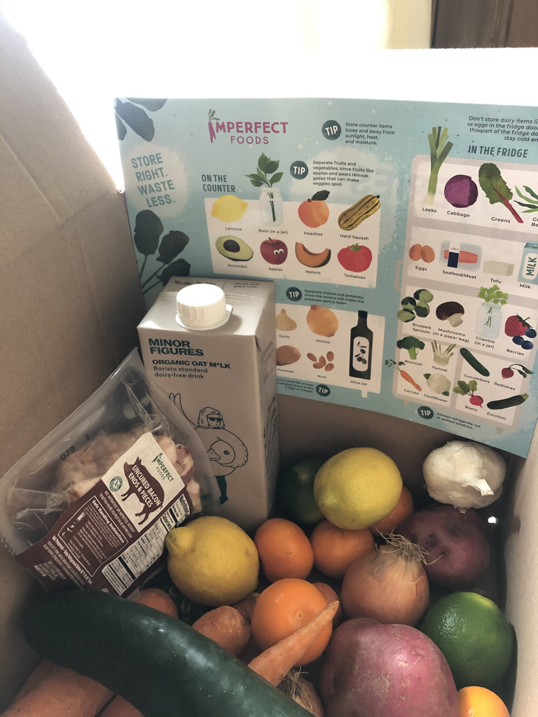 Box of vegetables and lemons and other food items from Imperfect Foods subscription box delivery.