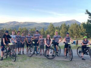 Group of teen and pre-teen bike riders in Colville, with view of hills and trees in background.