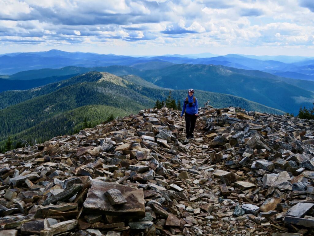 Hiker standing atop shale rocks on the summit of Abercrombie Mountain.