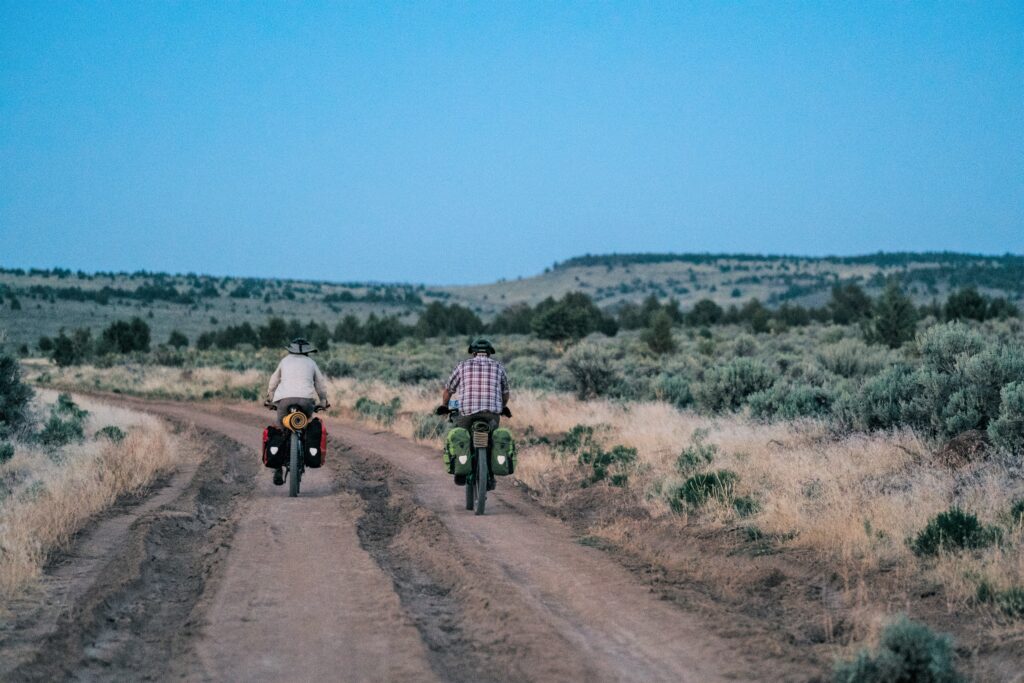 Biking dirt road up the shoulder of Steens Mountain, alongside sagebrush.