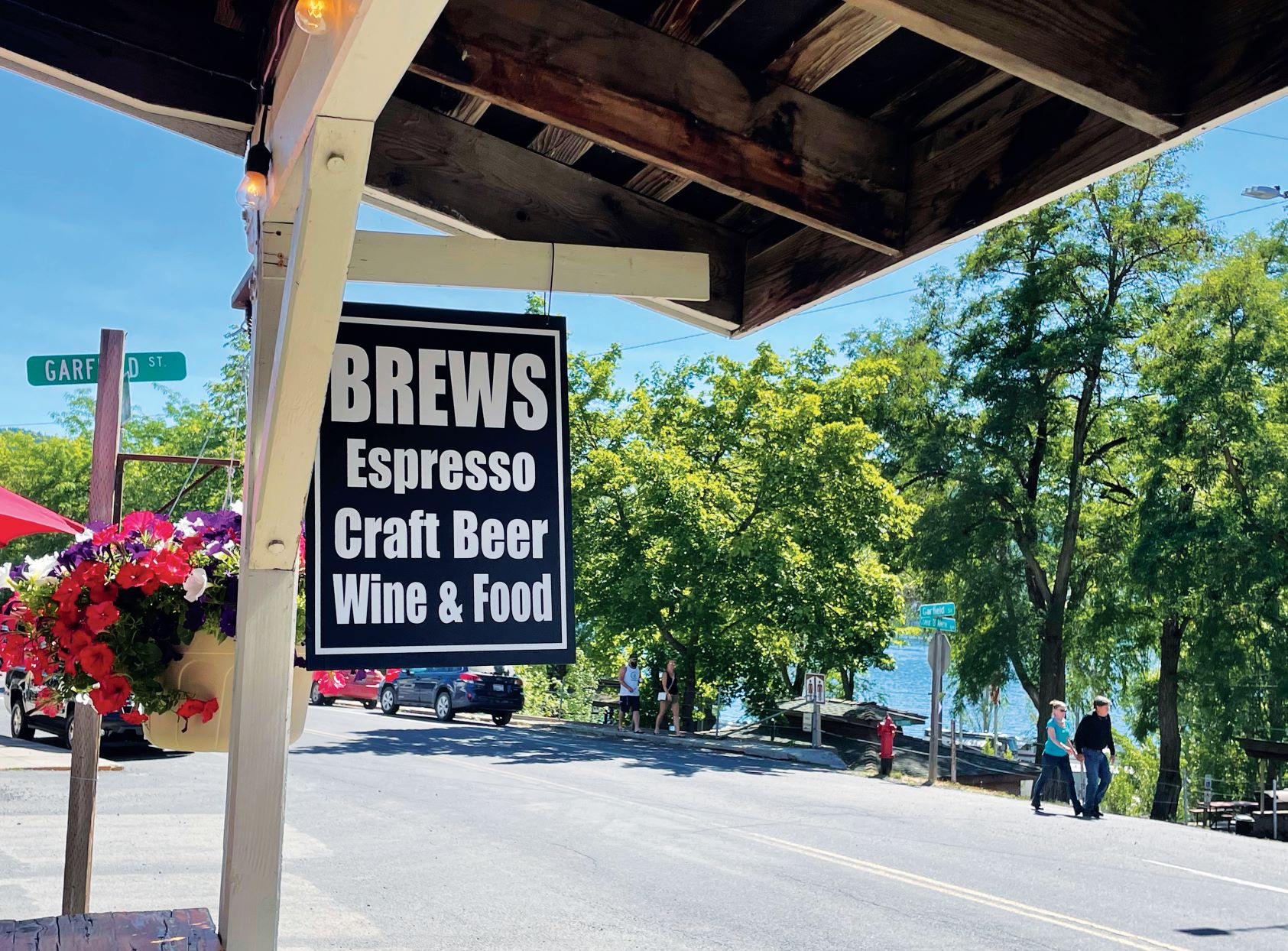 Wooden sign outside a cafe in Harrison, Idaho, that reads "Brews, Espresso, Craft Beer, Wine & Food."