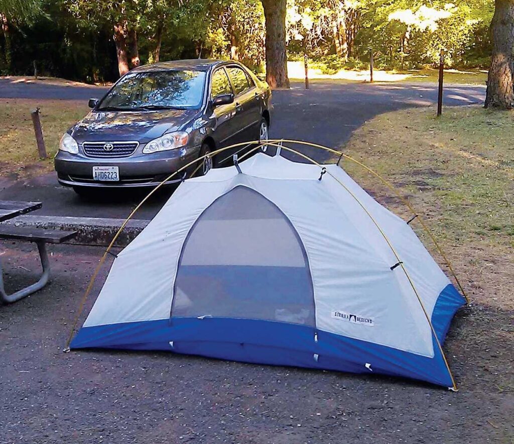 Compact Toyota car and small tent at a campsite.