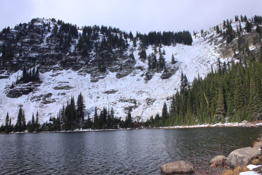 Blossom Lake with snow on the lakeshore hillside.