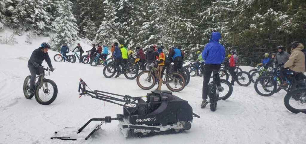 Bikers with their fat tire bikes gather before riding the snow-covered trails at Pine Street Woods during the Fatsquatch event.
