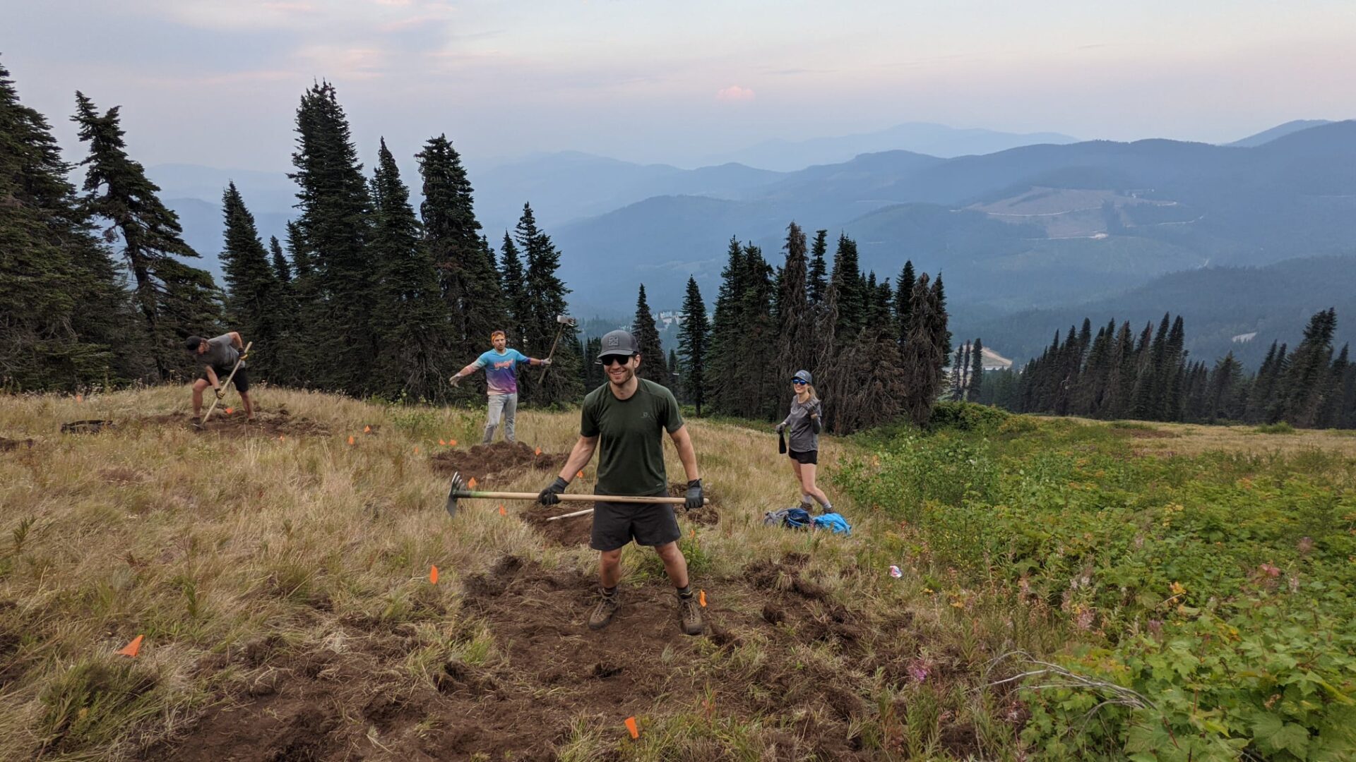 Trail building volunteers holding pulaski tools as they work at Mount Spokane.