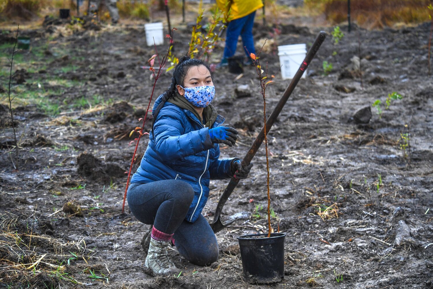 Woman at the tree planting event holding a shovel.