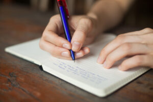 Person writing in a journal.