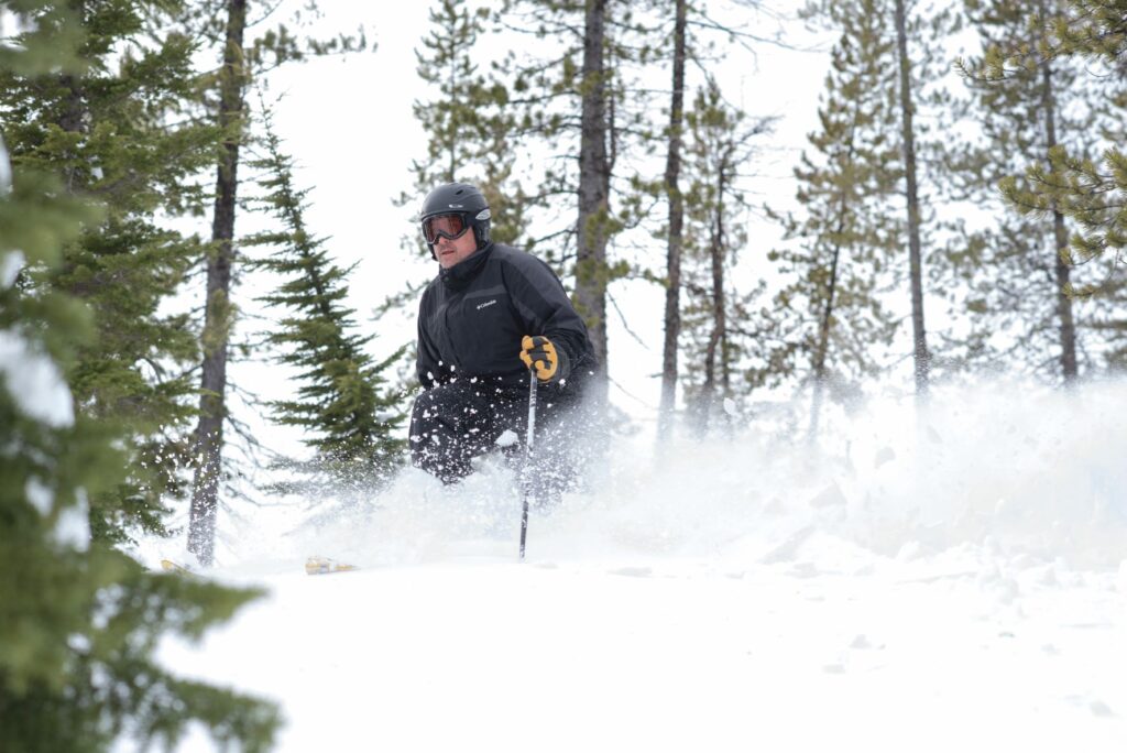 Matt Landheim skiing in deep powdery snow down through the upper glades (trees) off Eagle Peak. Photo by James Nisbet.