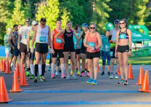 Group of runners of all genders at the start line for the Coeur d'Alene Marathon.