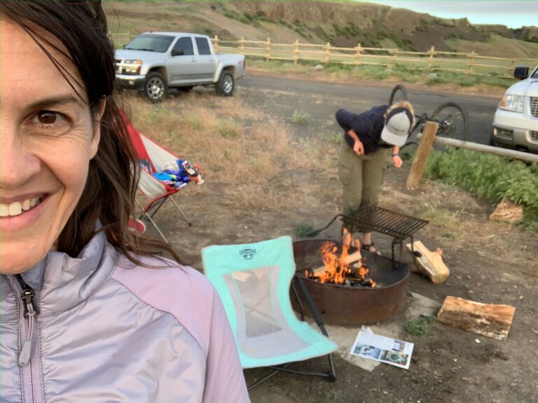 Shallan selfie photo with Carol in the background tending to a campfire.