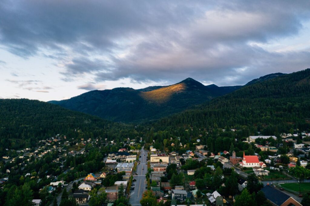 Aerial view of Rossland, B.C., featuring tree-lined city streets and surrounding mountain landscape.