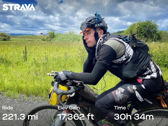 Cyclist Justin Short on his gravel bike looking tired after riding over 200 miles, 30 miles, with over 17,000 feet of elevation gain.