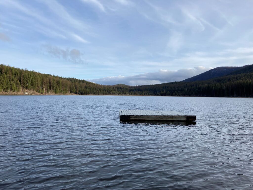 View of Lost Lake and a floating dock just a short way off shore at the campground beach.