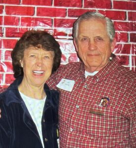 Jackie and Lee Bratcher smiling at camera with Lee's arm around his wife.