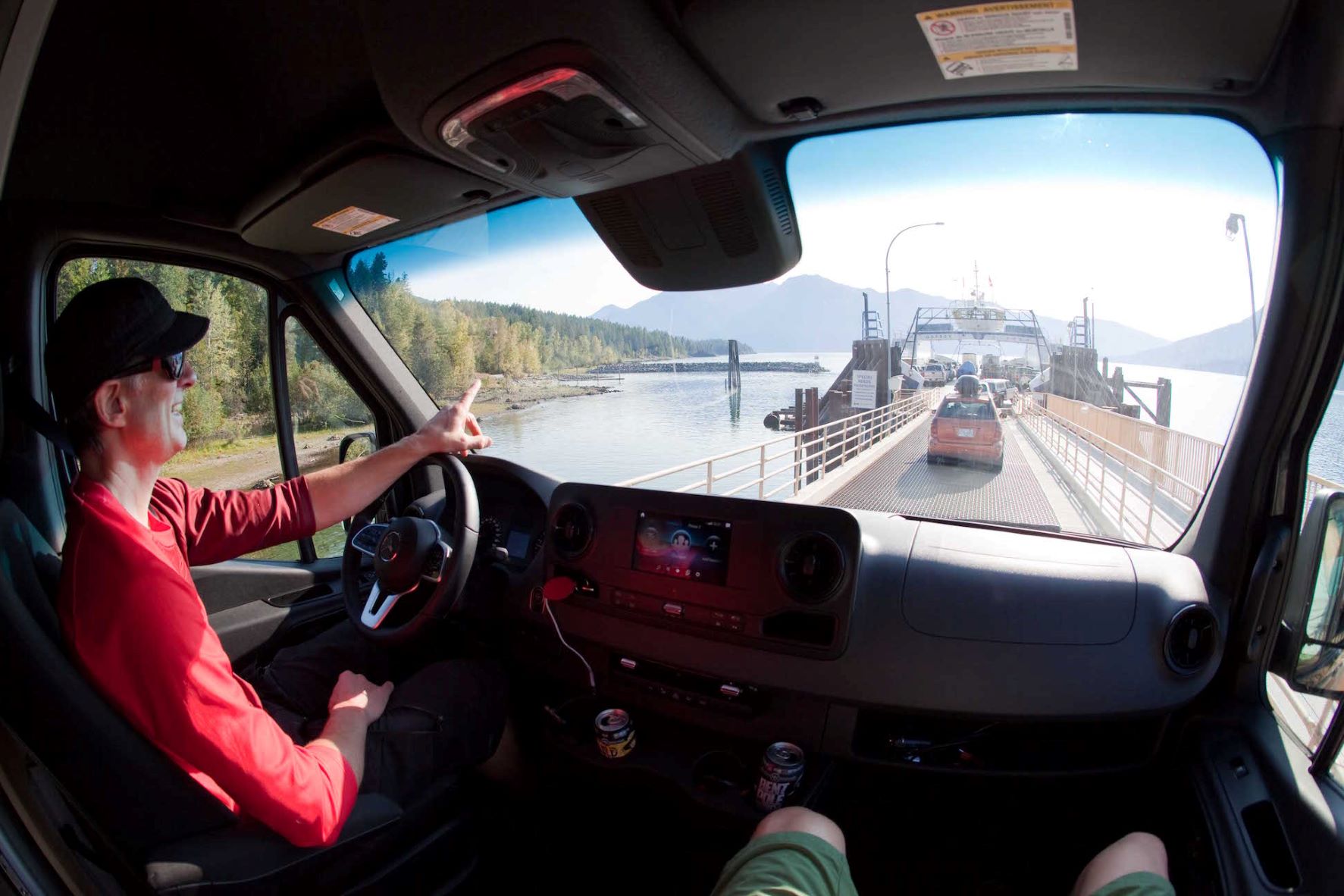 Man in the driver's seat of Sprinter van driving onto the loading dock of the Kootenay Lake Ferry.