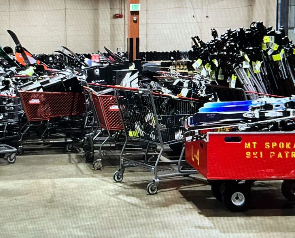 Reg wagon that says Mt. Spokane Ski Patrol on its side, carrying a load of new snowboards and skis for sale at the annual ski swap event.