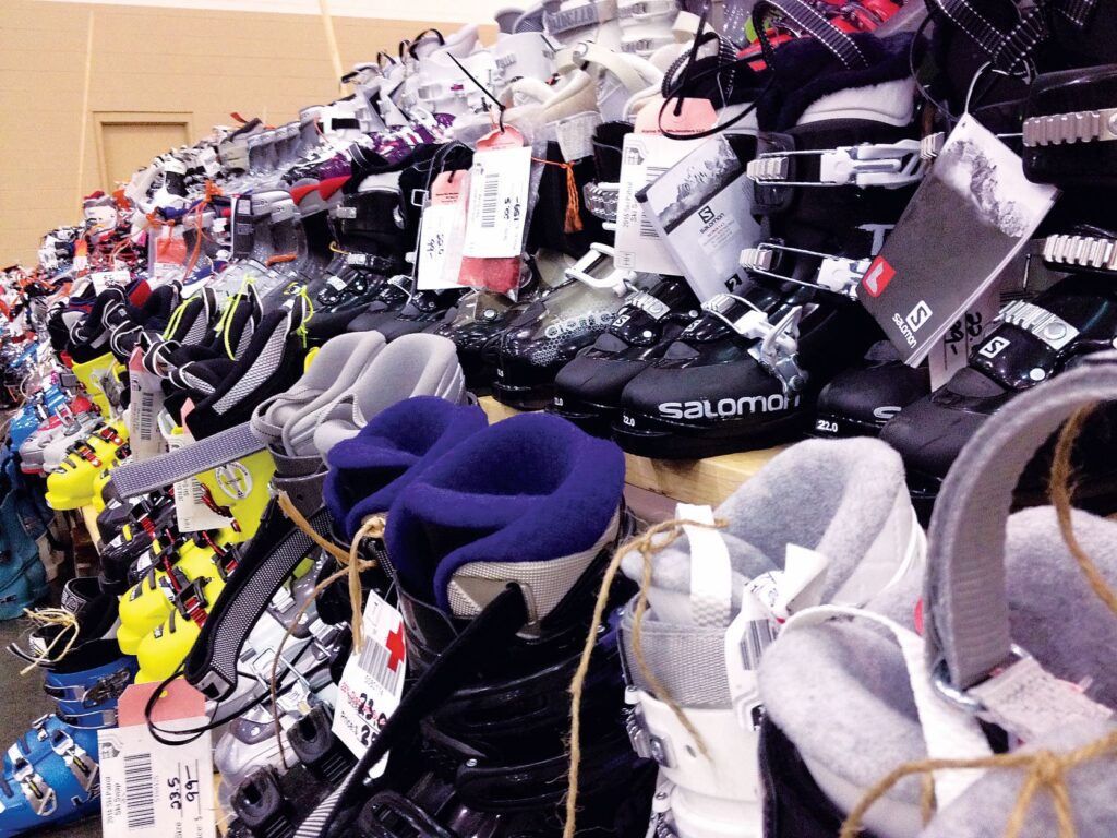 Display of ski boots with price tags at ski swap sales event.