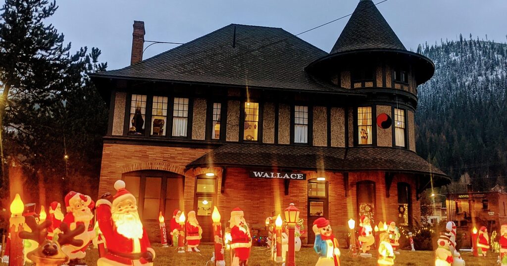 Christmas light display in front of a home including lit-up Santas and bears.